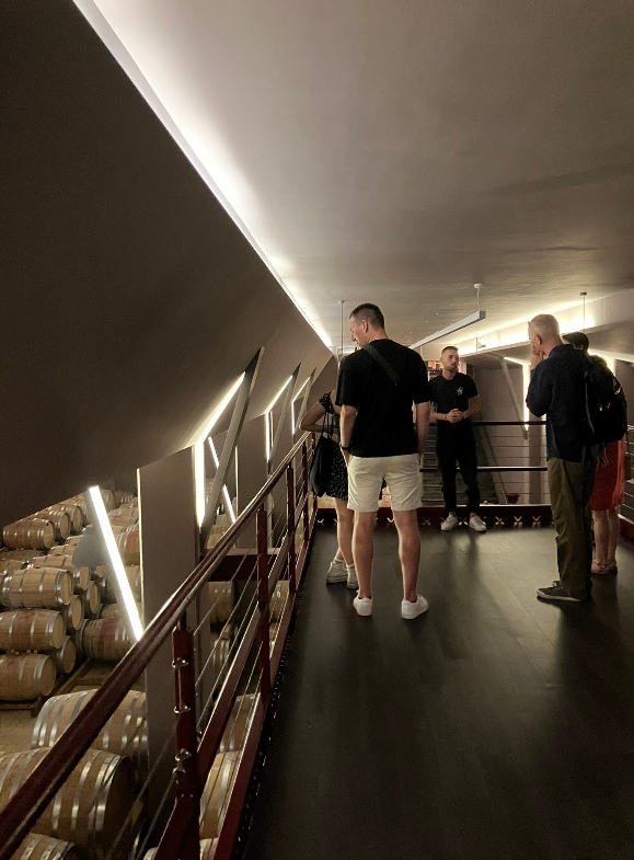 Wine tourists visit the underground aging cellar of the winery during a visit
