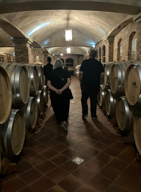Wine tourists stroll in the aging cellar amid the oak bariques
